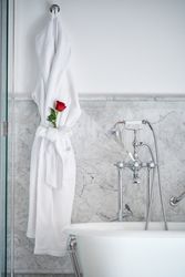 Interior of bathroom with bathrobe with fresh red rose