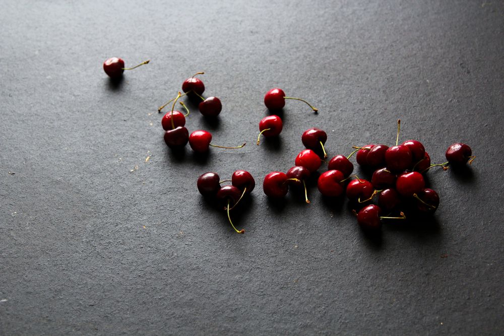 Shiny ripe red cherries on dark background