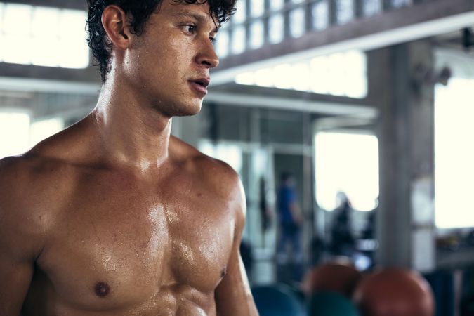 Portrait of muscular man sweating after workout in gym