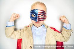Serious blond boy wearing American flag mask making muscles 4Bogdb
