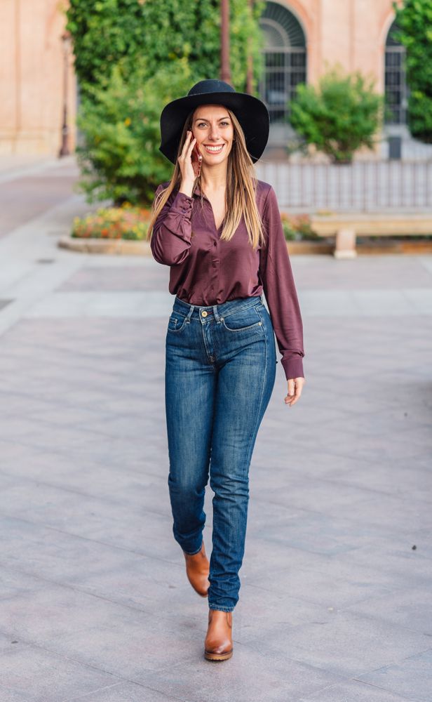 Woman in trendy outfit talking on smartphone