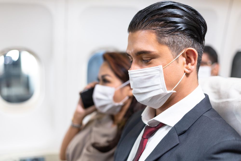 Male and female sitting next to each other on airplane