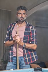 Pensive bearded man standing with cue