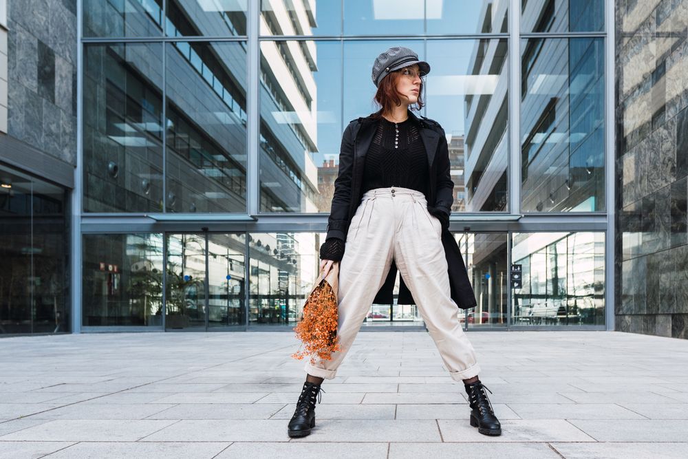 Stylish female holding flowers on street