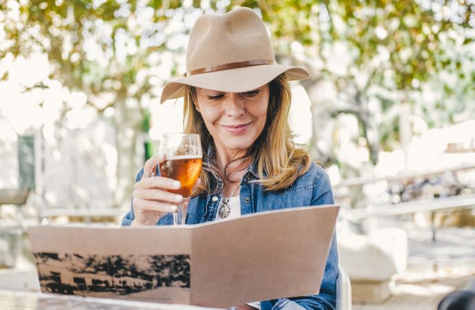 Woman sitting outside cafe drinking beer