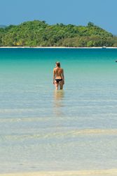 Woman resting in water on tropical seashore