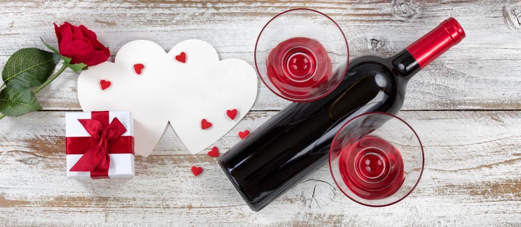 Valentine’s wine with gifts on rustic wood