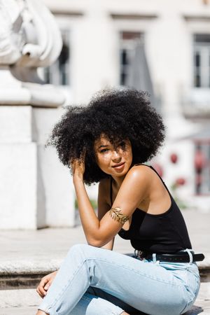 Black female sitting on stairs outdoors