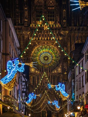 Angels lit up for Christmas time on road with Church in Alsace, France