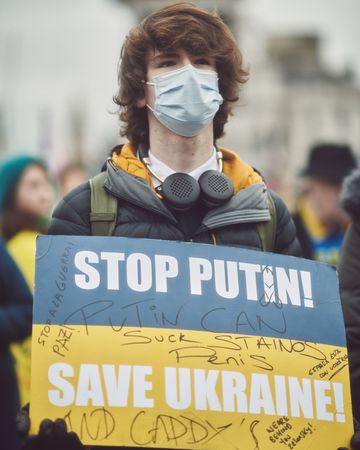 London, England, United Kingdom - March 5 2022: Young man in facemask with Ukrainian flag sign