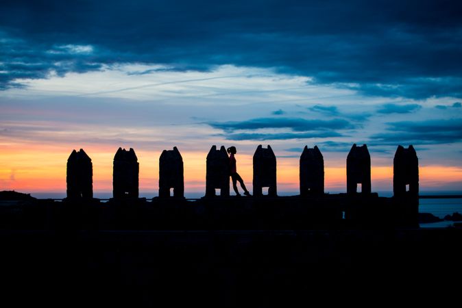 Silhouette of person between stone sculptures in sunset