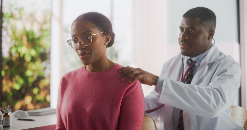 Black Female Passing a Health Examination by a Professional General Practitioner in a Modern Clinical Trial Room.