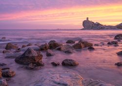 Sundown sky over sea and stony coast