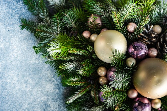 Close up of purple and gold Christmas centerpiece in pine branch with copy space