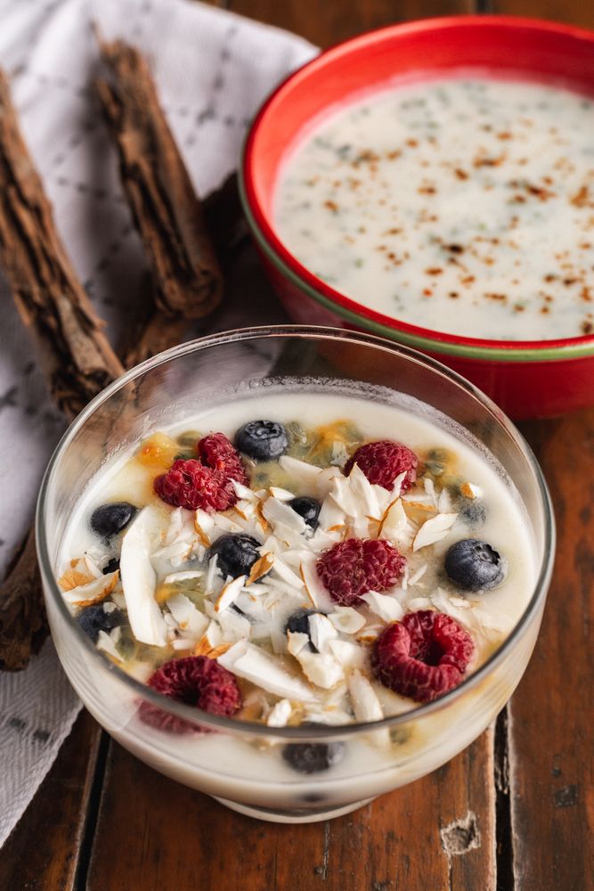 Yogurt in glass bowl with berries and cinnamon sticks