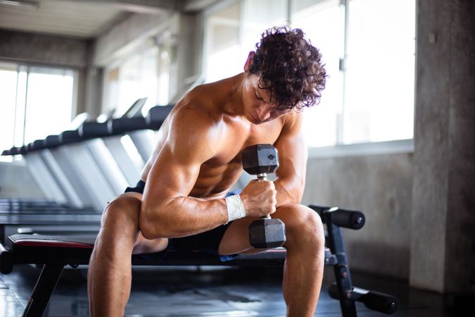 Athletic man lifting dumbbell for training exercise in fitness