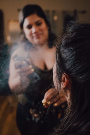 makeup artist using fixing spray for clients makeup