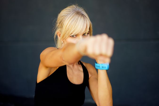 Fit woman punching ahead