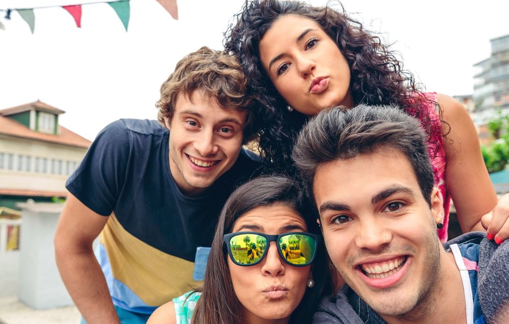 Friends standing outside sticking tongue out at camera