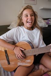 Excited child playing acoustic guitar at home