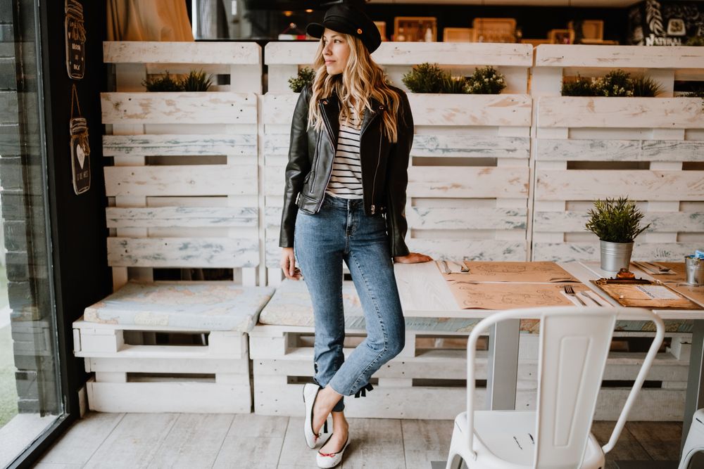 Casual stylish woman standing at table in cafe