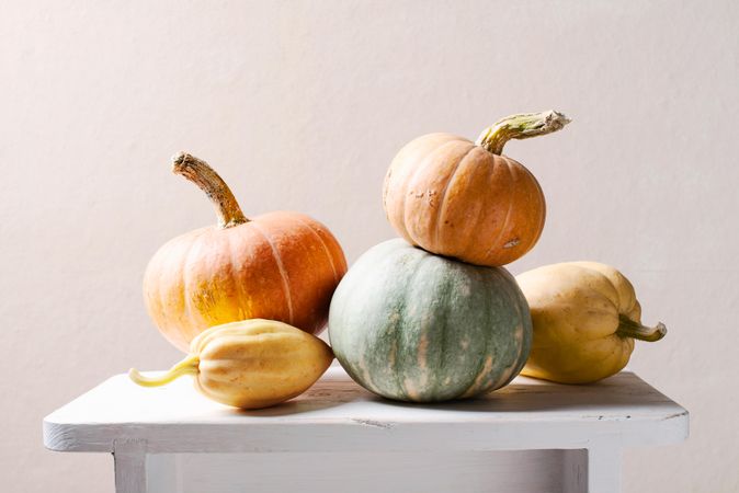 Variety of pumpkins stacked on wooden table