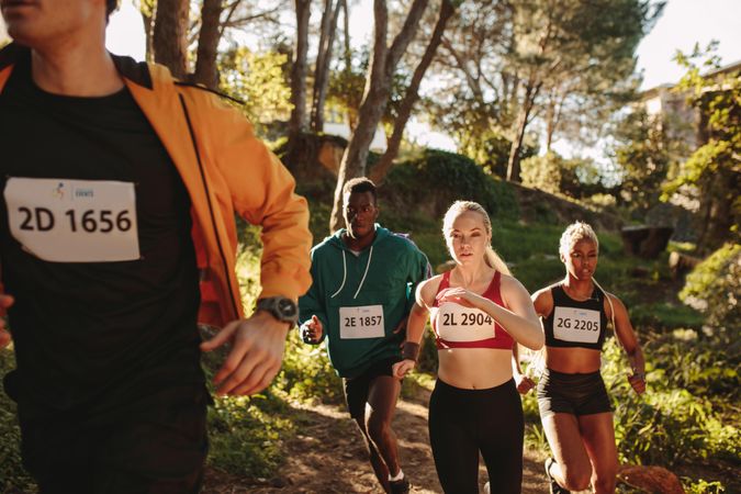 Multi-ethnic group of athletes running on mountain trail