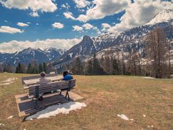 People sitting on bench in open air and looking at amazing landscape