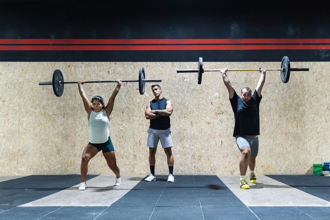 Hispanic sportspeople training with barbells