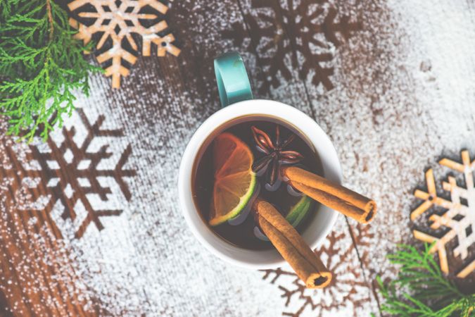 Top view of warm Christmas drink with citrus slice, cinnamon stick and anise star