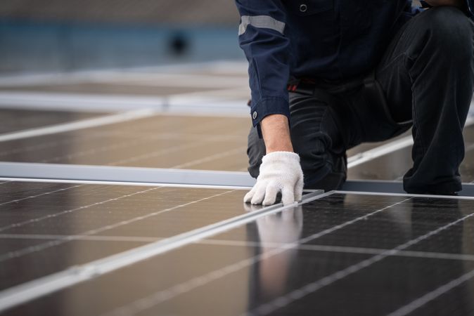 Engineer checking solar cell  or photovoltaic cell by electronic device installed on the roof of the factory. Technician worker repair or inspect the system. Industrial renewable energy concept