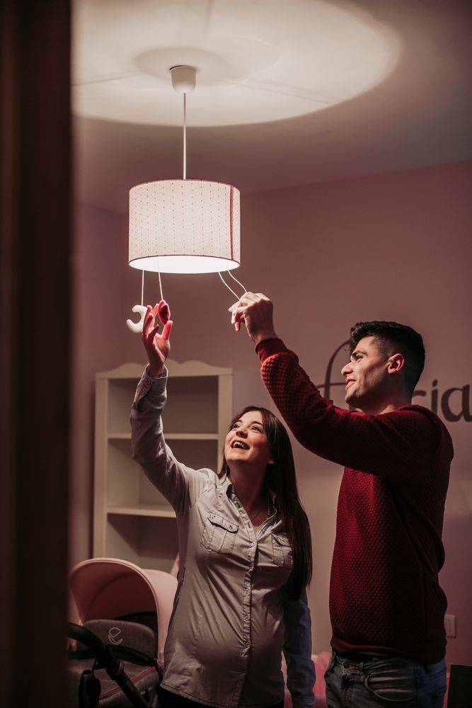 Expecting couple lighting chandelier in baby room