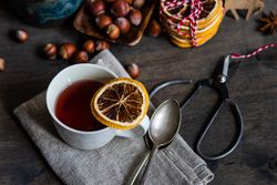Top view of slice of dried orange balanced on mug of tea