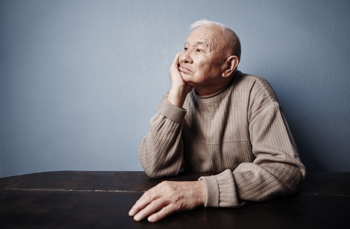 Pensive older man sitting at the table