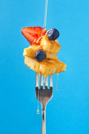 Appetizing fruit dessert with honey on fork