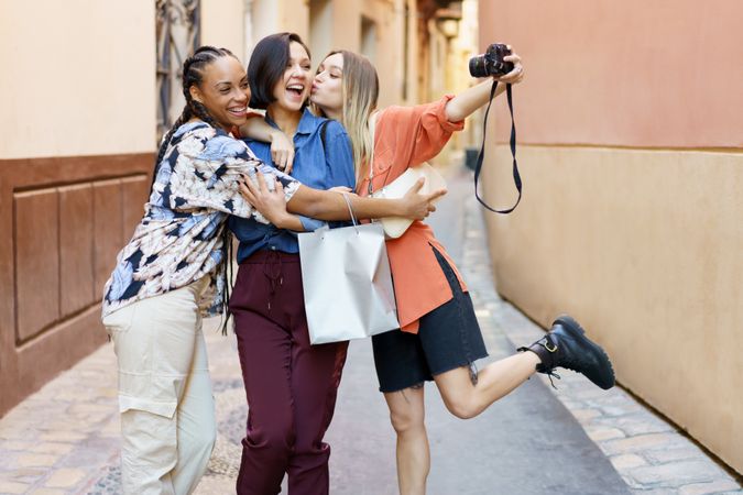 Three happy women in lane taking selfie with camera