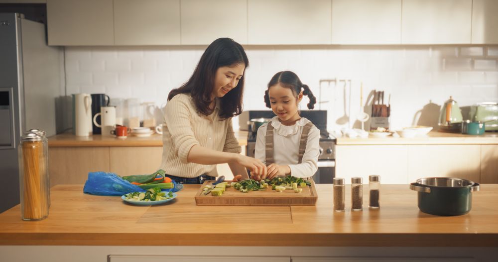 Korean Girl Helping her Mom With Making a Salad. They are Talking and Bonding