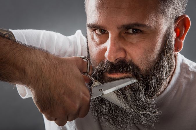 Expressive barber cutting beard