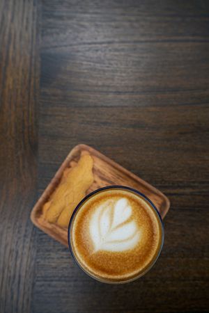 A portrait view of coffee cup and some bread on the table