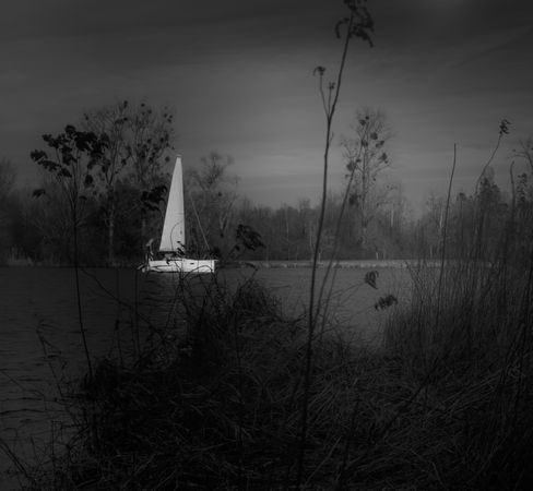 Monochrome shot of sailboat on a lake on overcast day
