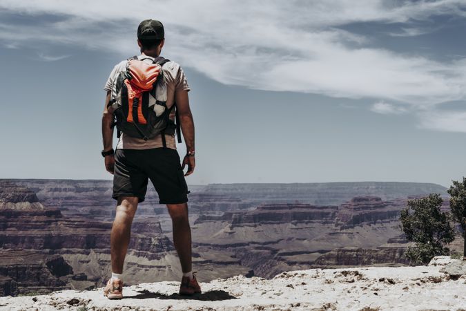 Tourist gazing while standing on edge of picturesque canyon