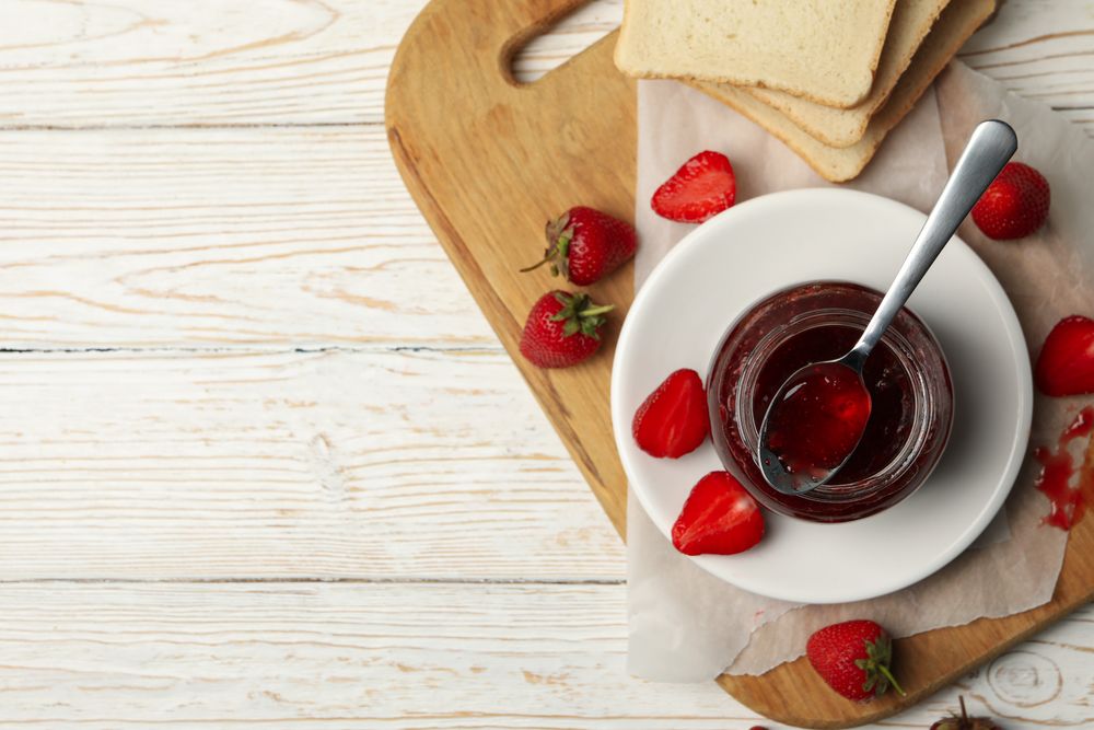 Composition with strawberry jam on wooden background, top view