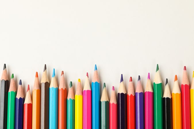 Colorful pencils on blank background, space for text