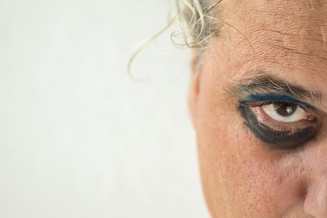 Middle aged man with dark and blue eyeshadow on right eye