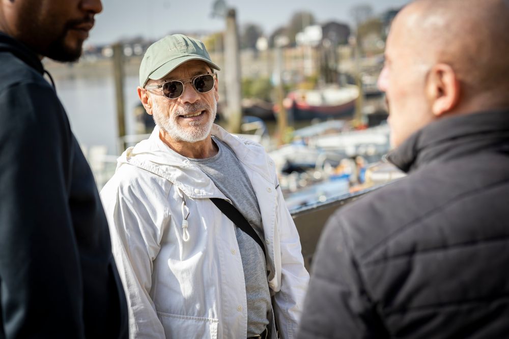 Older smiling male friends chatting together over river