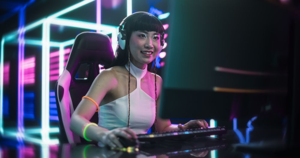 Stylish Asian Streamer or Gamer in White Clothes Chats with Internet Fans on Computer in Futuristic Cyber Technology Room.