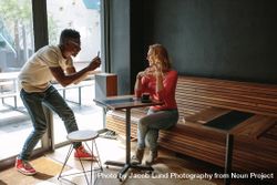 Woman sitting at a coffee shop posing for a photograph 5w26Z0