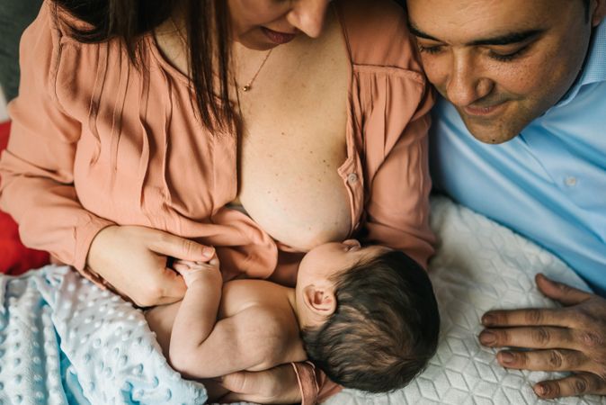 Mom near father breastfeeding at home