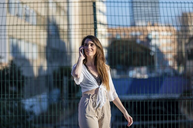Young woman standing in the street while speaking on mobile phone