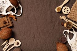 Top view of natural kitchen and bathroom accessories on brown fabric with copy space